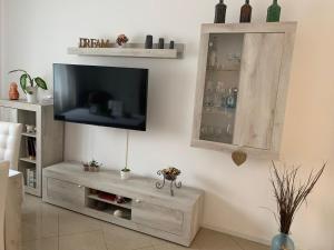 uma sala de estar com uma televisão de ecrã plano na parede em Al Capitello em Mira