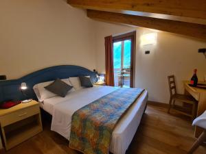 um quarto com uma cama grande e uma janela em Hotel Aigle em Courmayeur