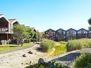 a row of houses with a pond in a park at 4 person holiday home in Bogense in Bogense