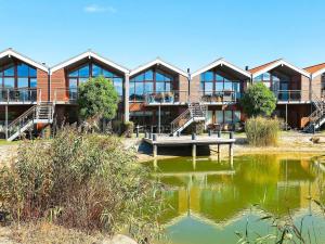 a building with a pond in front of it at 4 person holiday home in Bogense in Bogense