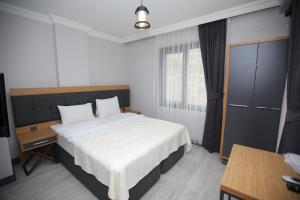 um quarto com uma grande cama branca e uma janela em AKTAŞ SUITE em Trebizonda
