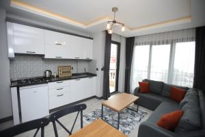 een woonkamer met een bank en een keuken bij AKTAŞ SUITE in Trabzon