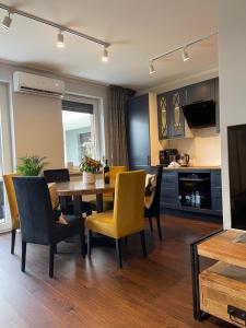 kuchnia i jadalnia ze stołem i krzesłami w obiekcie Luxury Maślice Apartment we Wrocławiu