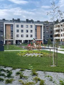 un parque con parque infantil frente a un edificio en Luxury Maślice Apartment en Wroclaw