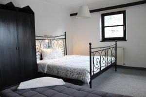 a bedroom with a black bed and a window at Apartments Hermann Arnold in Sölden
