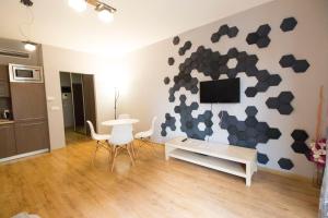 a living room with a table and a tv on a wall at Happy Apartments - Just In Center in Wrocław