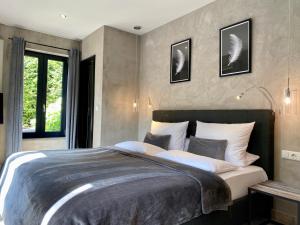 Un dormitorio con una cama grande y una ventana en country-suites by verdino LIVING - Apartments & Privatzimmer, en Braunlage