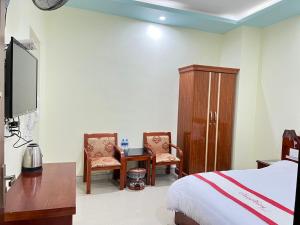 a bedroom with a bed and a desk and chairs at Huy Hoàng Hotel in Dồng Văn +24 photos