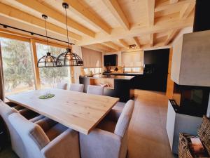 kuchnia i jadalnia z drewnianym stołem i krzesłami w obiekcie Mei-Chalet w mieście Bad Kleinkirchheim