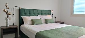 a bedroom with a large bed with a green headboard at Suites Direzionale Carpi in Carpi