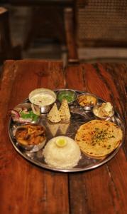 a plate of food on a wooden table at Sugar Cube Retreat in Shimla