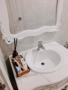 een badkamer met een witte wastafel en een spiegel bij thiên phú hotel in Ho Chi Minh-stad