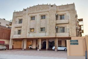 a building with cars parked in front of it at OYO 589 Lavina House in Jeddah