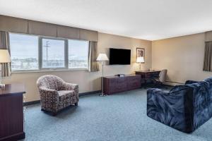 a hotel room with a couch and a chair and a television at Travelodge by Wyndham Fort St John in Fort Saint John