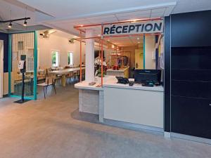 a reception area in a room with tables and chairs at ibis Budget La Teste Bassin d'Arcachon in La Teste-de-Buch