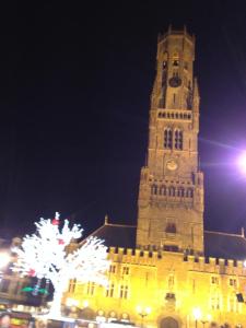 wysoką wieżę z zegarem w nocy w obiekcie Bruges Grande Place Guesthouse w Brugii