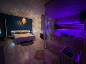 a bedroom with a bed and purple lighting at Sauna en bord de rivière in Morez