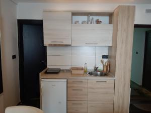 a kitchen with wooden cabinets and a sink at Apartman Marija M13 Milmari in Kopaonik