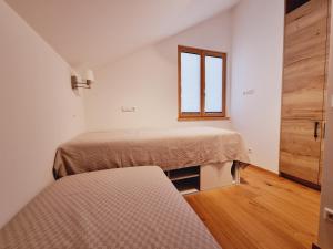 sypialnia z dwoma łóżkami i oknem w obiekcie Mei-Chalet w mieście Bad Kleinkirchheim