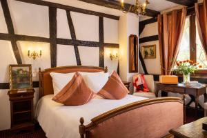 ein Schlafzimmer mit einem Bett mit Kissen darauf in der Unterkunft Hotel Restaurant Le Maréchal - Teritoria in Colmar