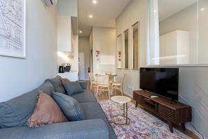 een woonkamer met een blauwe bank en een televisie bij 31 Janeiro 157 - Stylish 1BR w/ AC & Balcony by LovelyStay in Porto