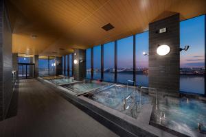 a large bathroom with two hot tubs in a building at Villa Fontaine Grand Haneda Airport in Tokyo