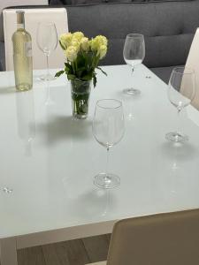 una mesa con copas de vino y un jarrón de flores amarillas en Miles building 2, en Londres