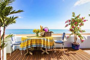 stół i krzesła na balkonie z plażą w obiekcie LUXURY BEACH PROPERTY- Neptune's Nest w mieście Sandgate