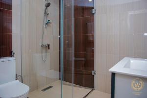 a bathroom with a shower with a toilet and a sink at Welcome Inn Hotel in Yerevan