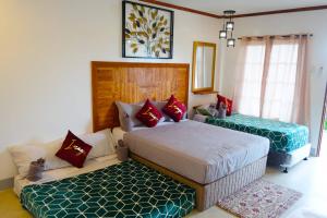 a bedroom with two beds and a couch at Gem's Paradise Resort in Cebu City +39 photos