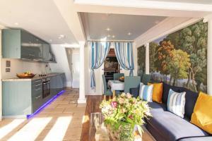 a living room with a blue couch and a kitchen at LUXURY BEACH PROPERTY- Neptune's Nest in Sandgate