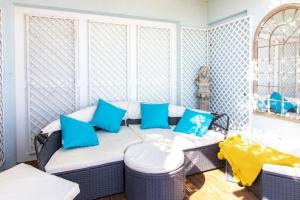 ein Wohnzimmer mit Sofa und blauen Kissen in der Unterkunft LUXURY BEACH PROPERTY- Neptune's Nest in Sandgate