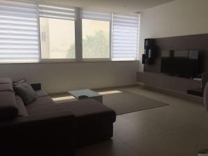 a living room with a couch and a flat screen tv at THE ONE - 4 Bedroom St Julian’s in St. Julianʼs