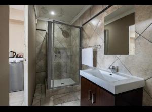 un baño con lavabo y ducha en Boat Yard Guest House, en Hartbeespoort 35 fotos más