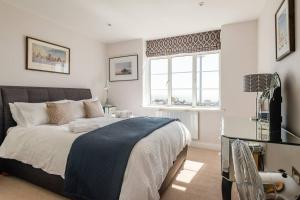 a bedroom with a large bed and a window at Spacious and luxe two king bedroom sea-view apt in Brighton & Hove