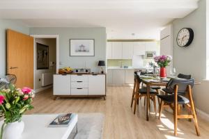 a kitchen and living room with a table and chairs at Spacious and luxe two king bedroom sea-view apt in Brighton & Hove