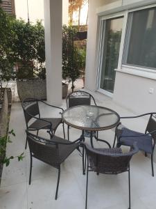 un tavolo in vetro e sedie su un patio di Apartment with terrace a Portoroz