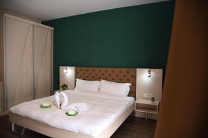 ビトラにあるGold Feliciaの緑の壁のベッドルーム1室(白い大型ベッド1台付)