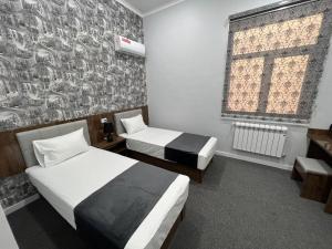 卡尔希TASHRIF HOTEL的有两张床和一扇窗户的酒店房间