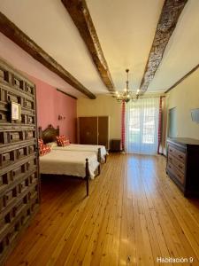a bedroom with two beds and a wooden floor at La Posada de Pesquera in Pesquera de Duero +72 photos
