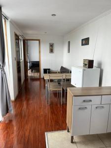 a kitchen and dining room with a table and refrigerator at Casa Container in San Antonio