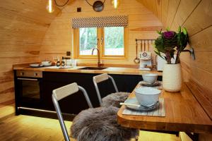 een keuken met een tafel met stoelen en een wastafel bij Cliff Stud Retreat - Luxury lodges and cosy cottages in Helmsley