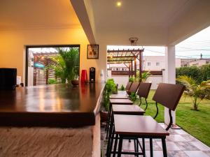 een bar met een rij stoelen en een tafel bij KoKo Palm Inn in Accra