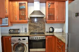 a kitchen with a stove and a washing machine at 53 Sea Lodge Umhlanga Rocks in Durban