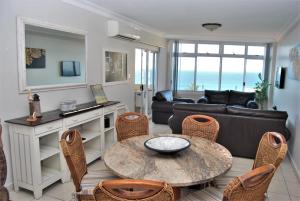 a living room with a couch and a table and chairs at 53 Sea Lodge Umhlanga Rocks in Durban