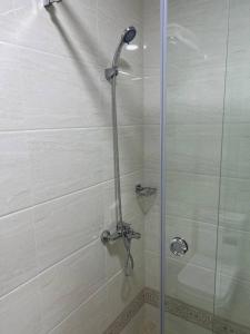 y baño con ducha y puerta de cristal. en TASHRIF HOTEL, en Qarshi