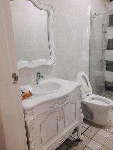 uma casa de banho branca com um lavatório e um WC em Thiên Phú Hotel em Ho Chi Minh