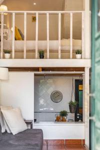 a loft bed with a couch in a room at Alcântara · Cool Tailor Made Studio in Lisbon