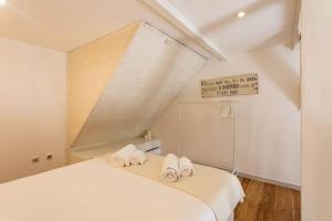 a bedroom with a bed with two towels on it at Alcântara · Cool Tailor Made Studio in Lisbon