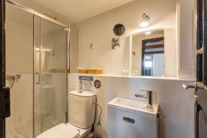 a bathroom with a shower and a toilet and a sink at Alcântara · Cool Tailor Made Studio in Lisbon